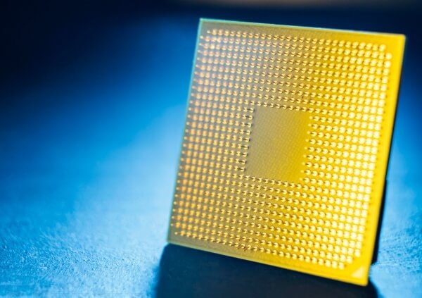 Close-up of a bare semiconductor die showing its grid-like surface, used in semiconductor packaging and assembly processes.