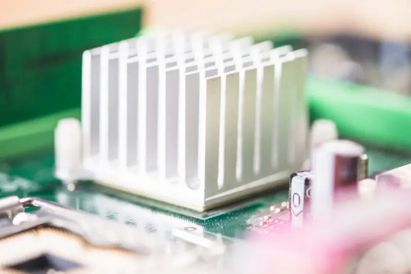 Substrate Material Selection: close-up aluminum heatsink on a PCB, highlighting thermal management and material choice in board design.
