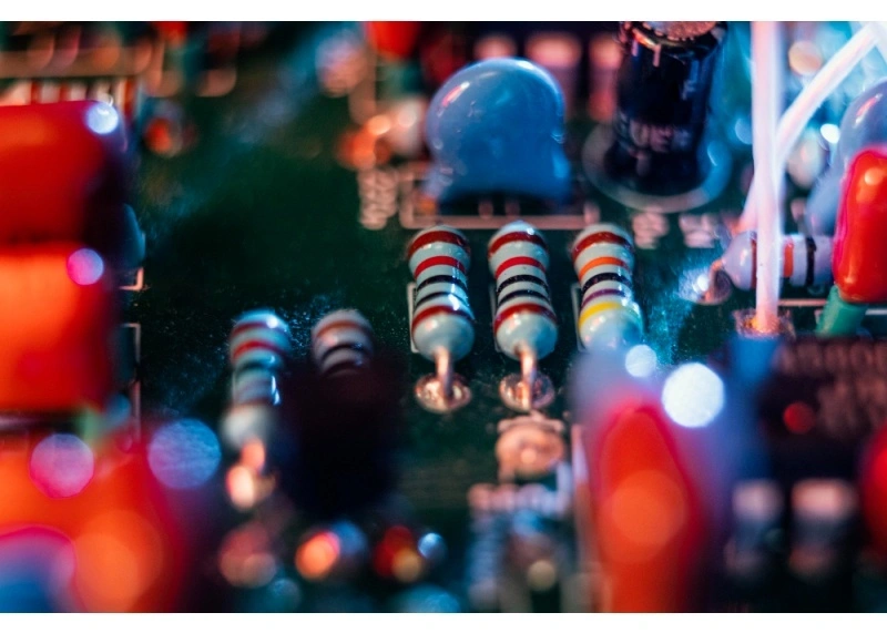 Macro of resistors and capacitors on a PCBA; small passives where tombstoning risk and thermal balance matter.
