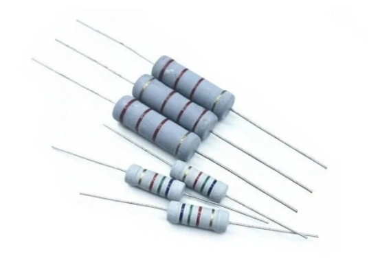 Assortment of axial-lead carbon film resistors with colored value bands, fundamental electronic components for circuit design, isolated on white background.