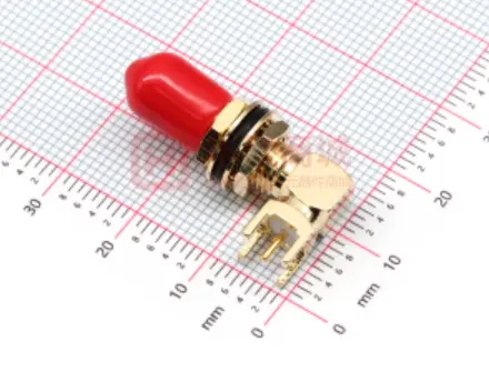 Close-up of a gold-plated right-angle SMA connector with a protective red cap.