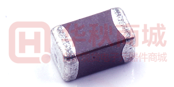 Close-up of a standard surface-mount Multilayer Ceramic Capacitor (MLCC) featuring a dark ceramic body and metallic terminations, used in high-density PCBA manufacturing.