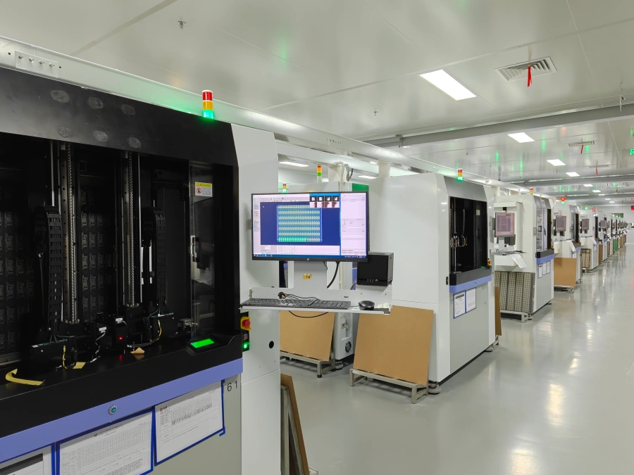 NextPCB | Row of flying probe test machines on a clean factory floor, each with a monitor showing the test software